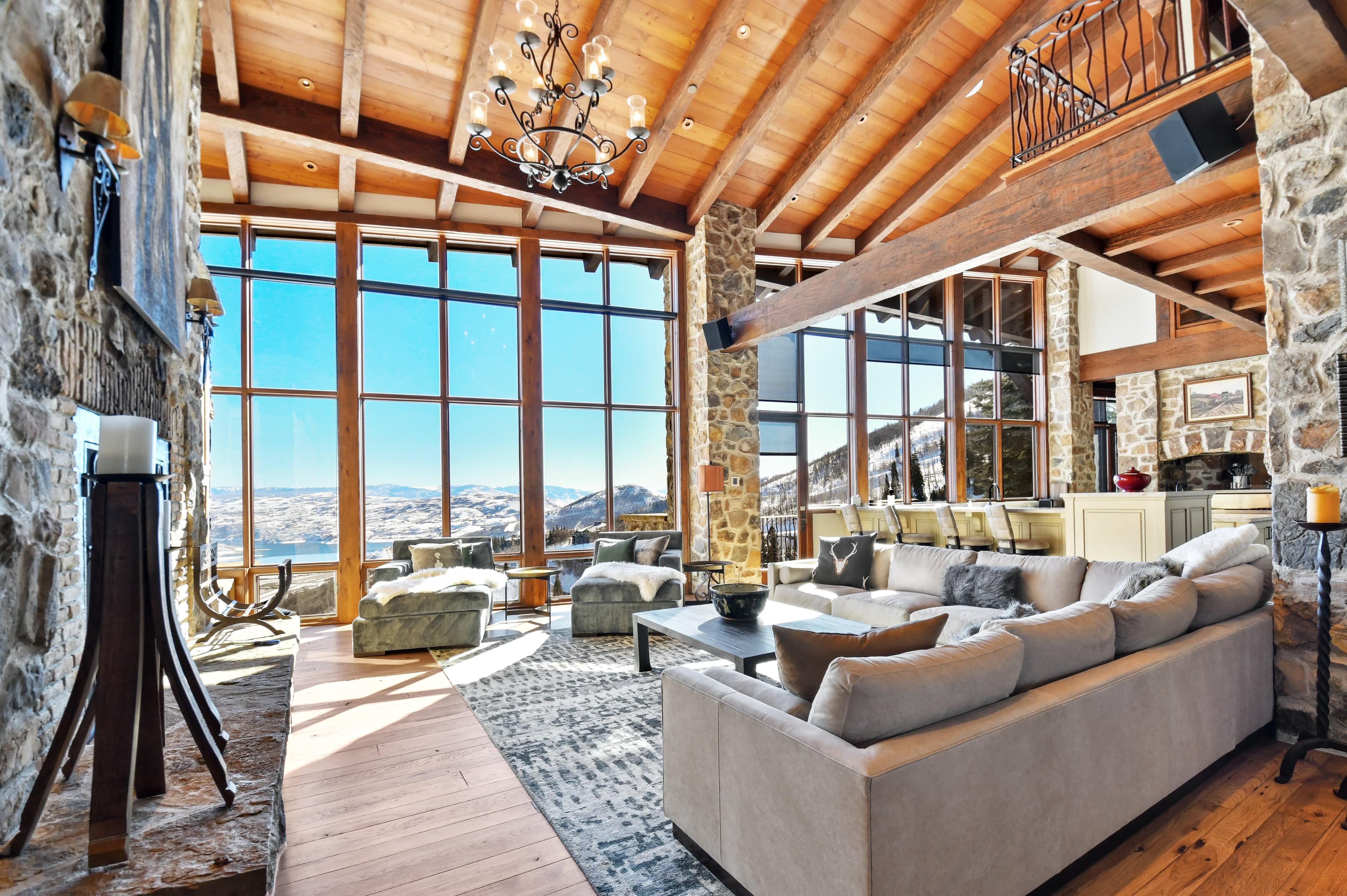Open-concept living area with vaulted ceilings, chandelier, and floor-to-ceiling windows.