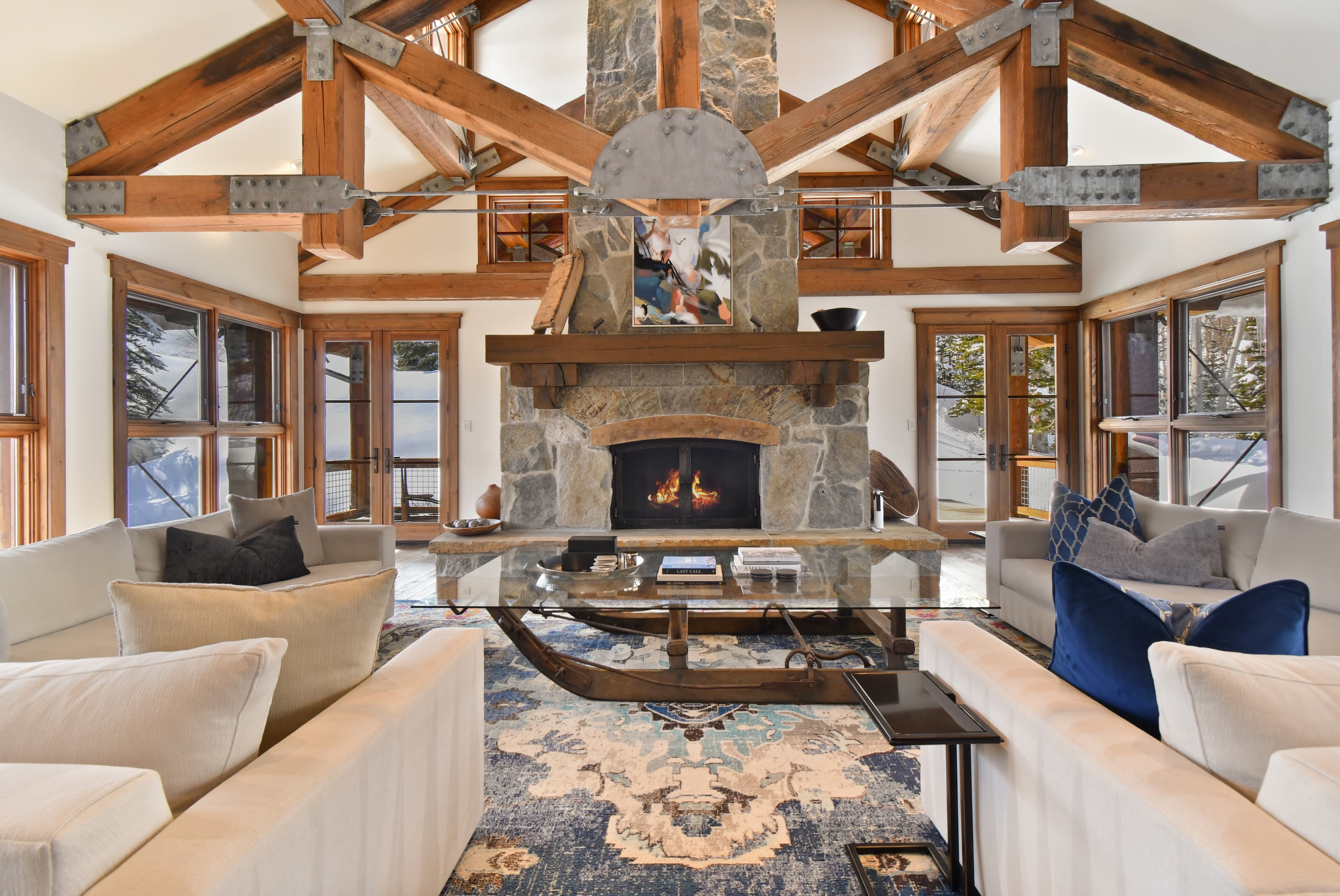 A photo centered on the lit fireplace of the main living area, and its large glass coffee table.