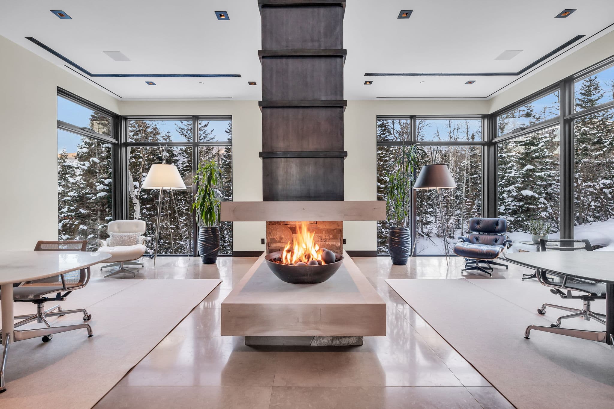 A stunning lounge with a statement fireplace and snowy views.