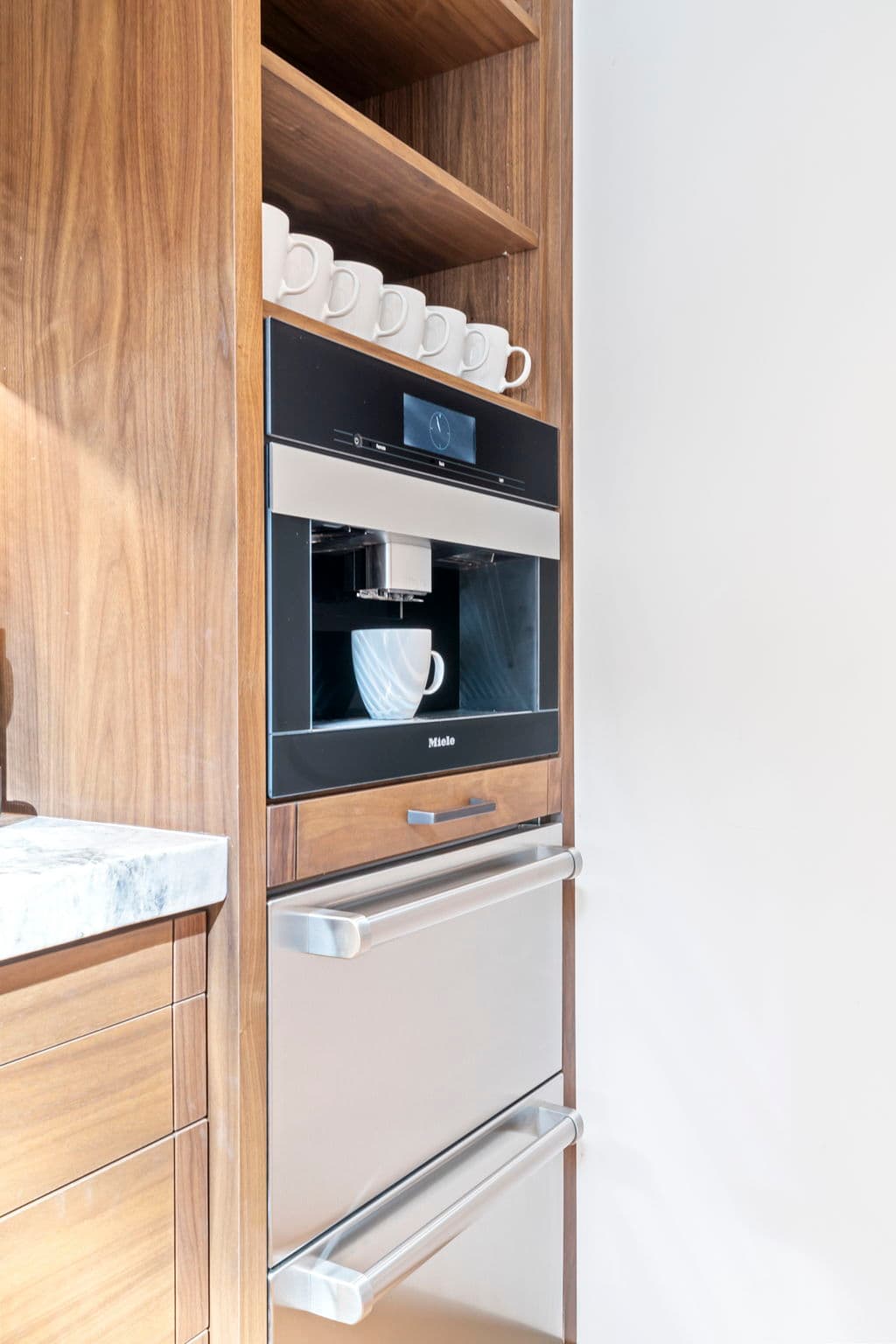 A view of the coffee bar with a coffee maker and mugs.