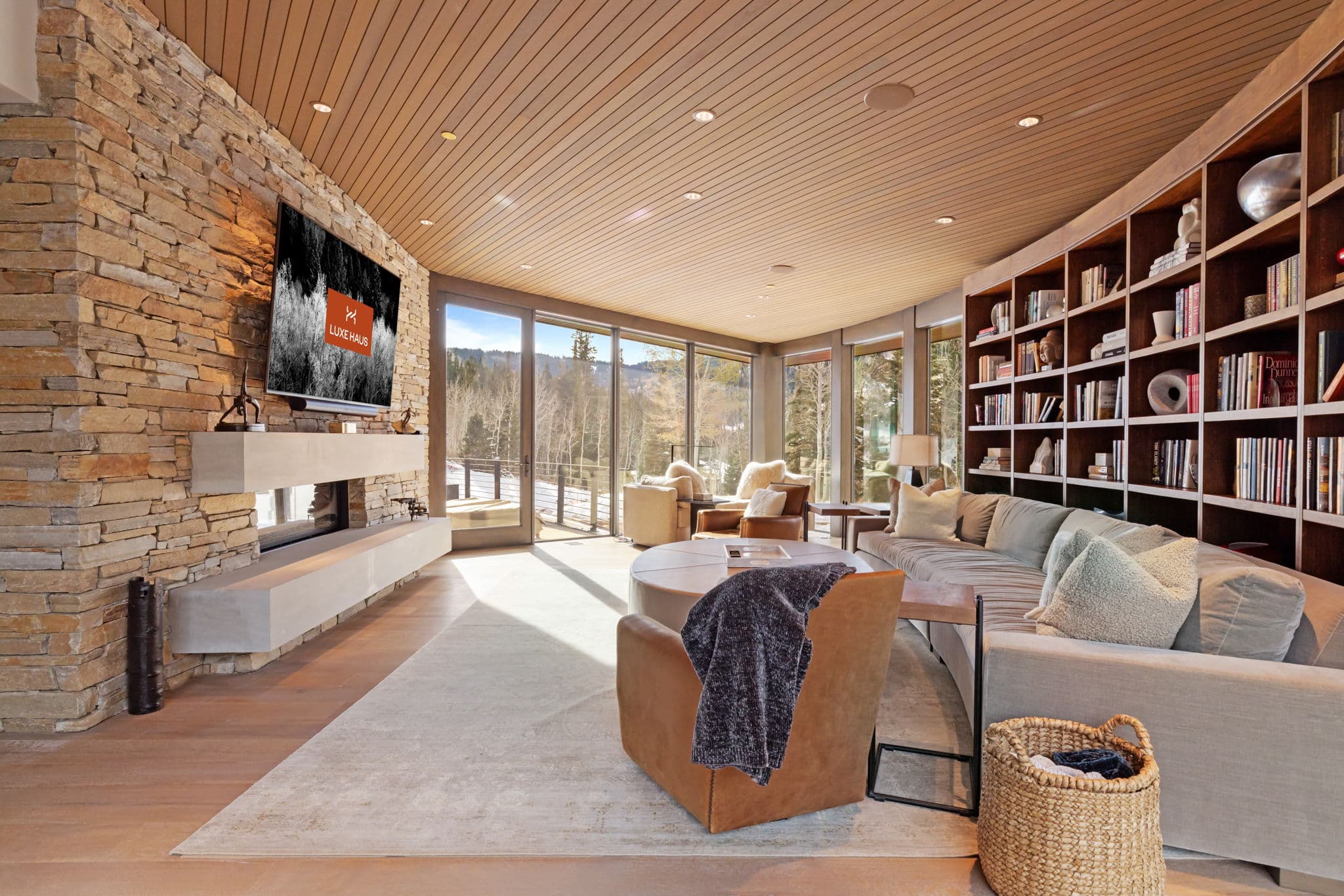 A living space with a sofa, chairs, and book case.